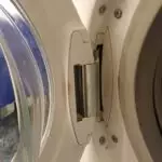 Zdjęcie zawiasu drzwi podczas wymiany obudowy drzwi w pralce Electrolux
