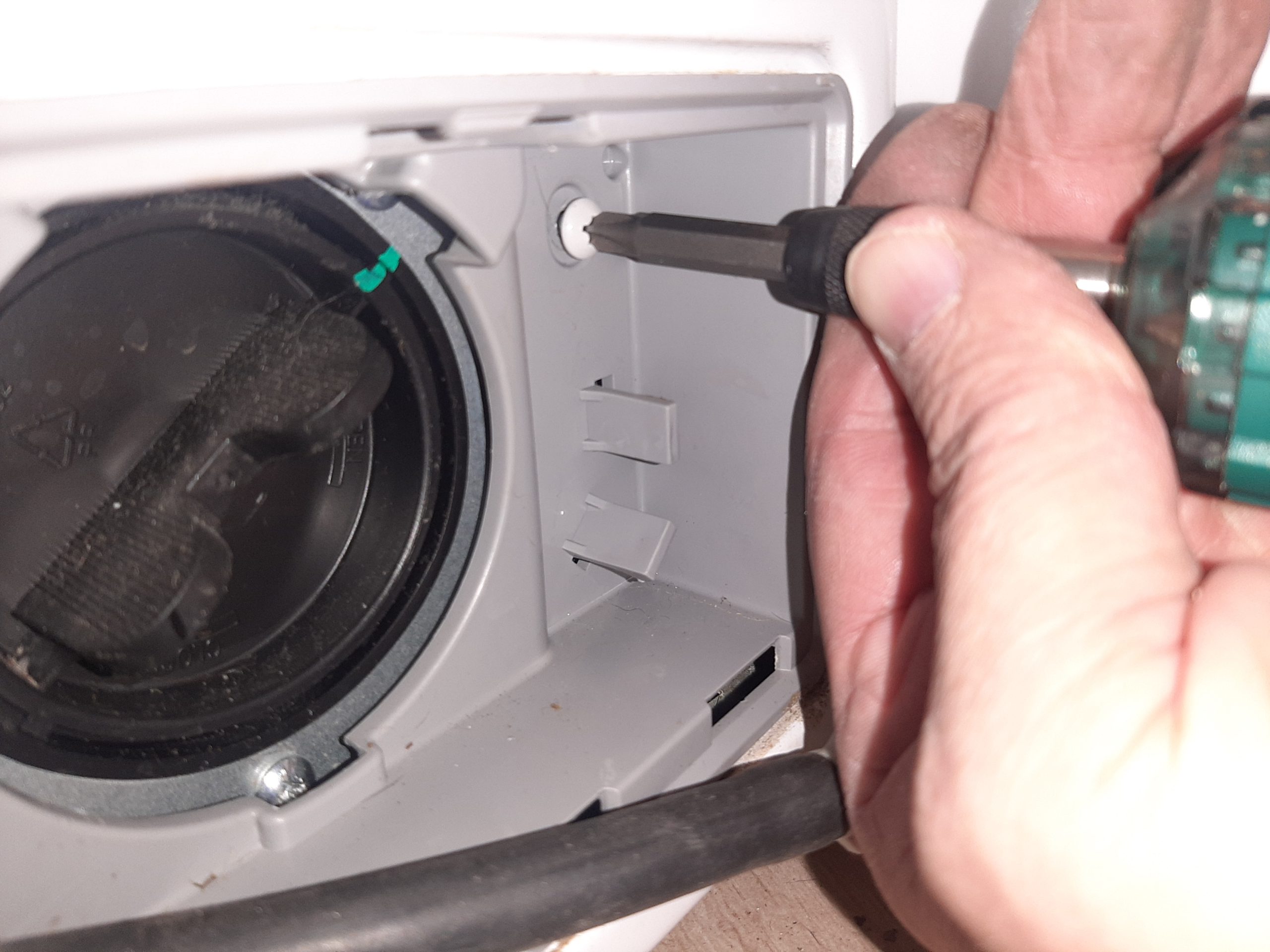 Odkręcić 1 wkręt trzymający pojemnik przed pompą wody - Instrukcja wymiany zniszczonego fartucha pralki LG F2J5WN4W