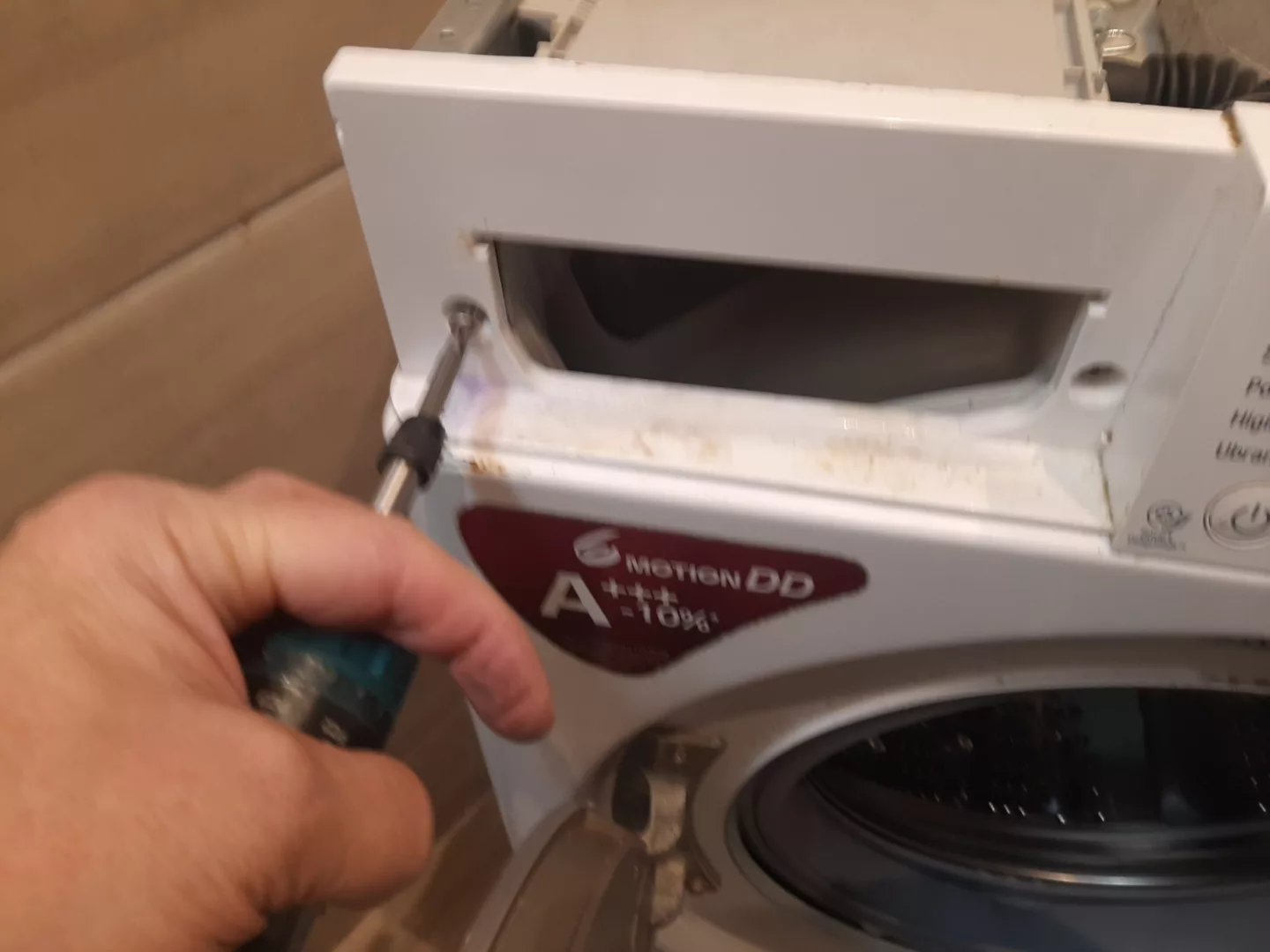 Odkręcić 2 wkręty pod szufladą - Instrukcja wymiany zniszczonego fartucha pralki LG F2J5WN4W
