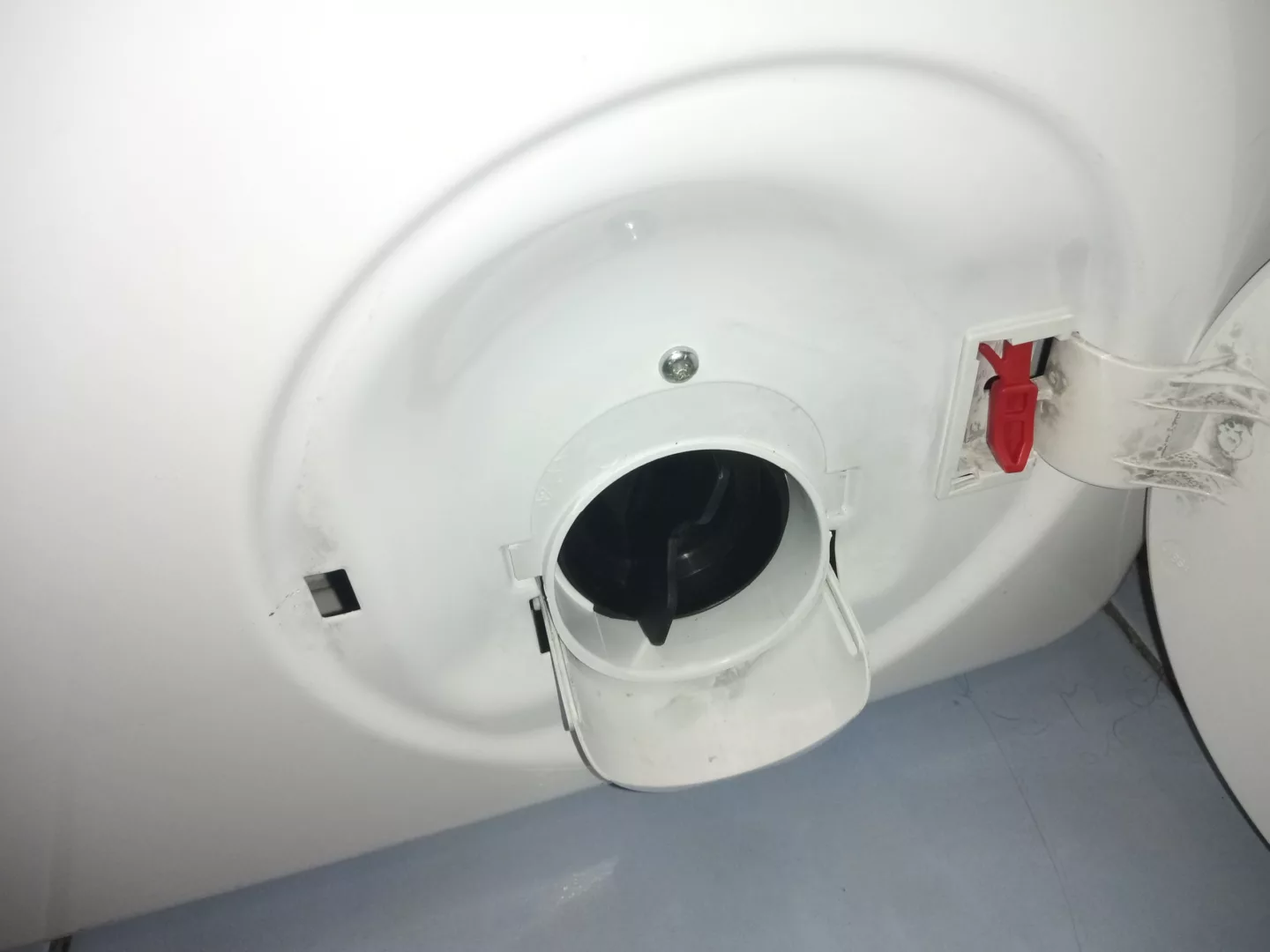 Odblokować drzwi awaryjnie czerwonym cięgnem umieszczonym obok filtra pompy, pociągając go w dół - wymiana silnika pompy pralki Gorenje PS1511120 P62S3P