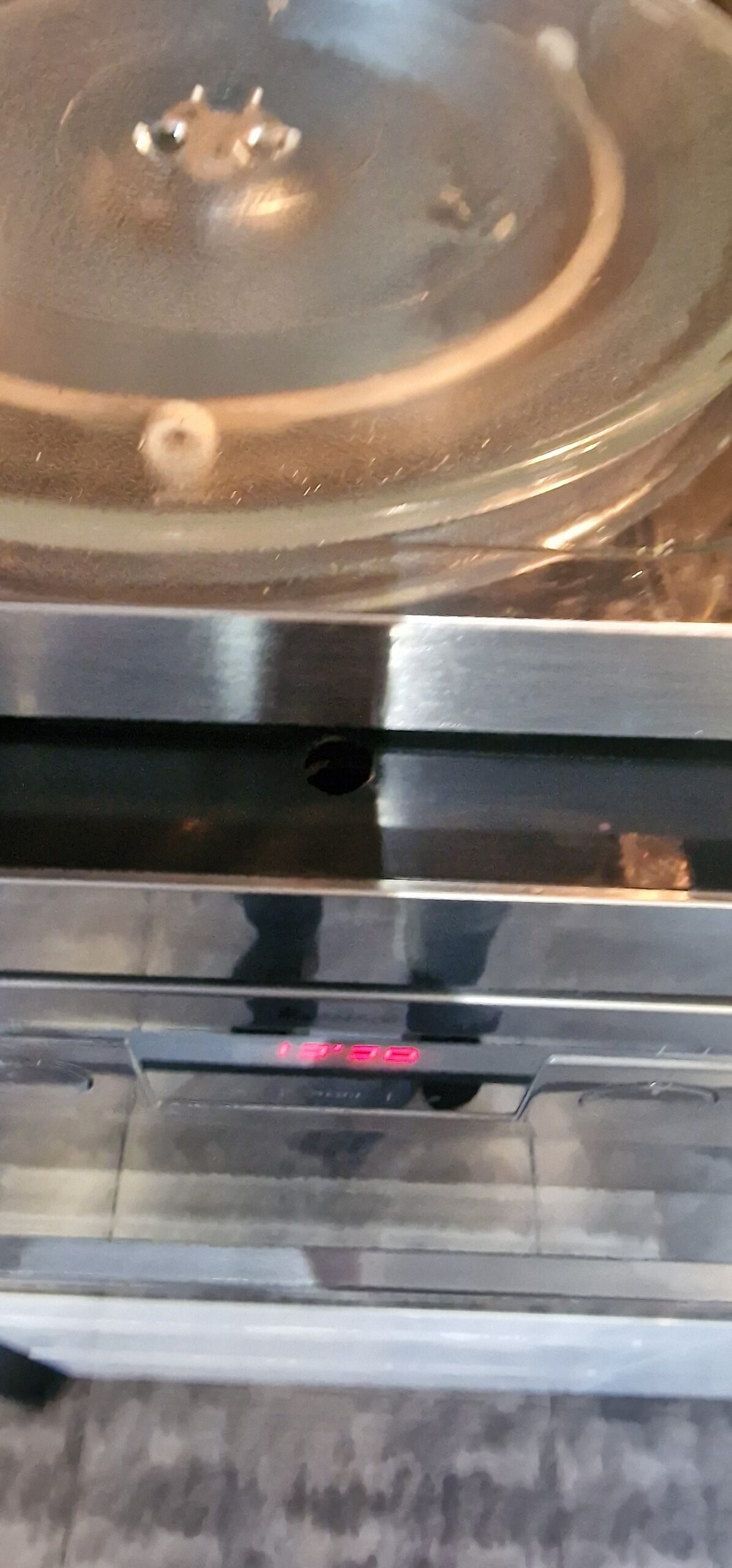 Widok na przednią część mikrofalówki Amica Integra AMM 25 BI - w której znajduje się śruba mocująca obudowę