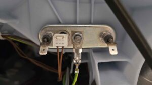 Wymiana uszkodzonej grzałki w pralce Bosch Home Professional WAY24742PL/09 - odłączamy przewody od grzałki