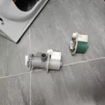Uszkodzona (zielona) pompa odpływowa wymontowana z pralki Beko MWTV6633BB oraz nowa pompa obok
