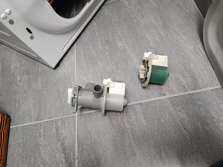 Uszkodzona (zielona) pompa odpływowa wymontowana z pralki Beko MWTV6633BB oraz nowa pompa obok