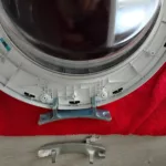 Wymiana uszkodzonego zawiasu drzwi w pralce Amica TAW 6123 LS - zdjęcie nowego oraz ułamanego zawiasu
